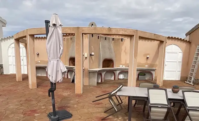 Bestaande buitenkeuken met gemetselde werkbladen, beige kolommen en terras